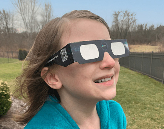 child wearing approved solar eclipse glasses