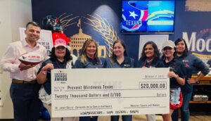 PBT Board Member Dr. Janet Garza, receiving a $20,000 donation check from Texans representatives, and Modelo representatives. 